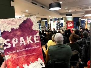 A photo of the SPAKE leaflet at the event itself, with a full crowd.